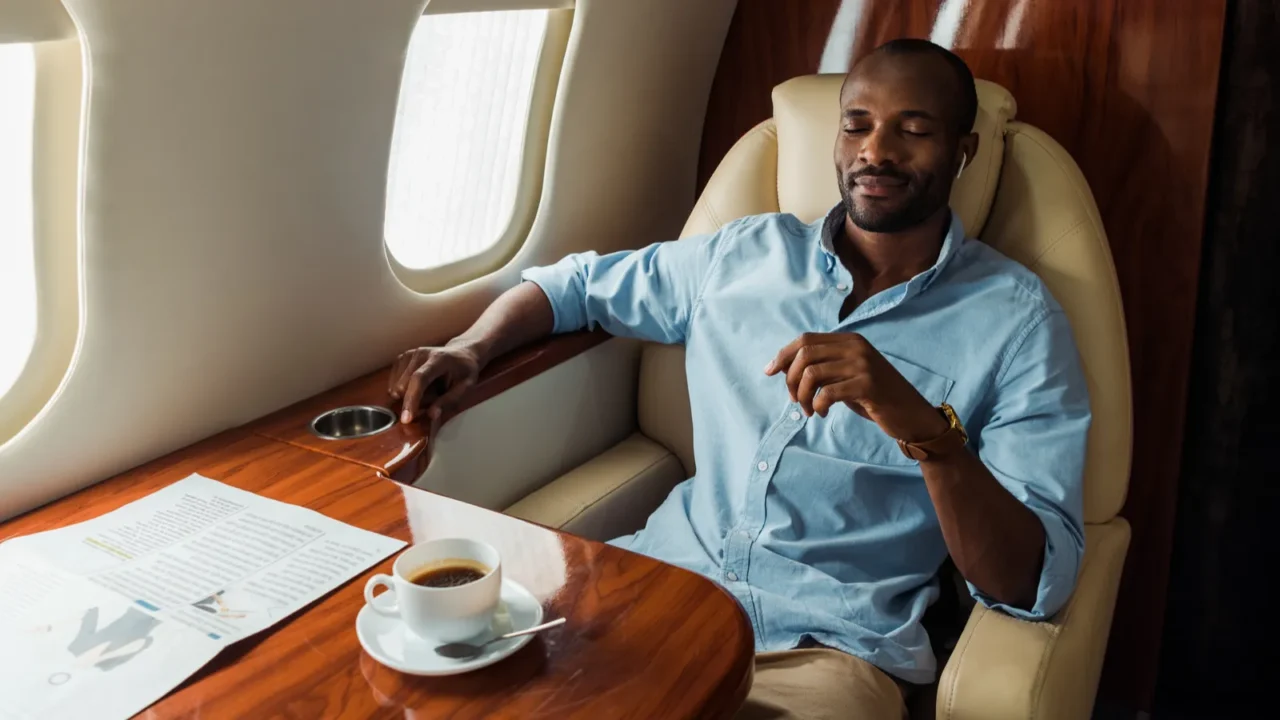 handsome african american man listening music in private plane