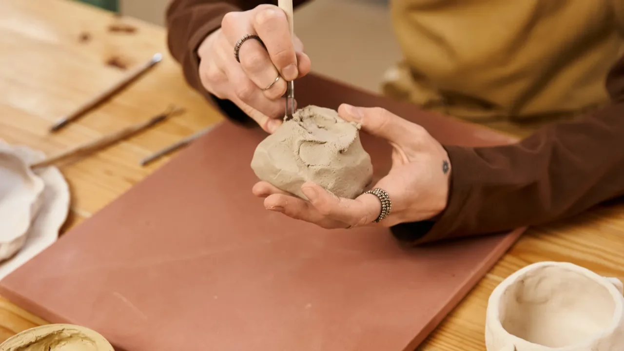 handsome man skillfully shapes clay in a pottery studio while