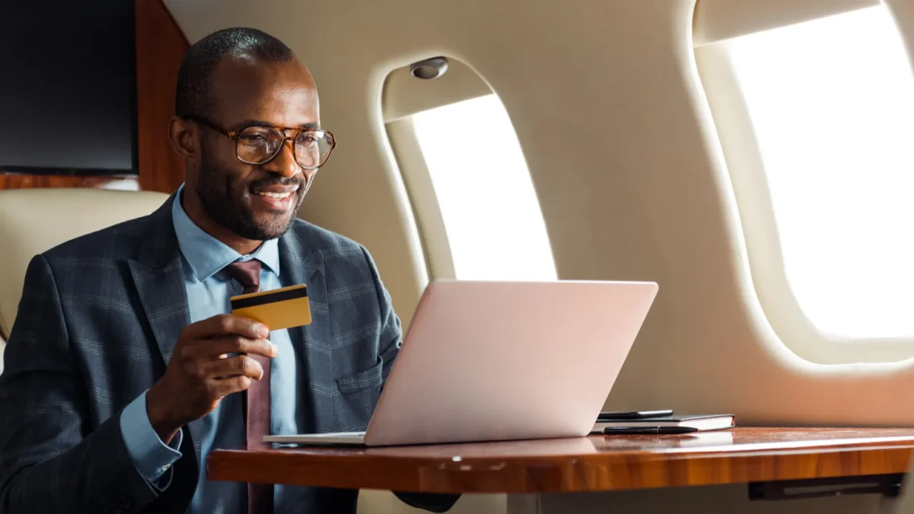 happy african american businessman in glasses holding credit card near