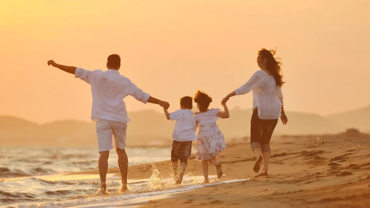 happy young family have fun on beach at sunset