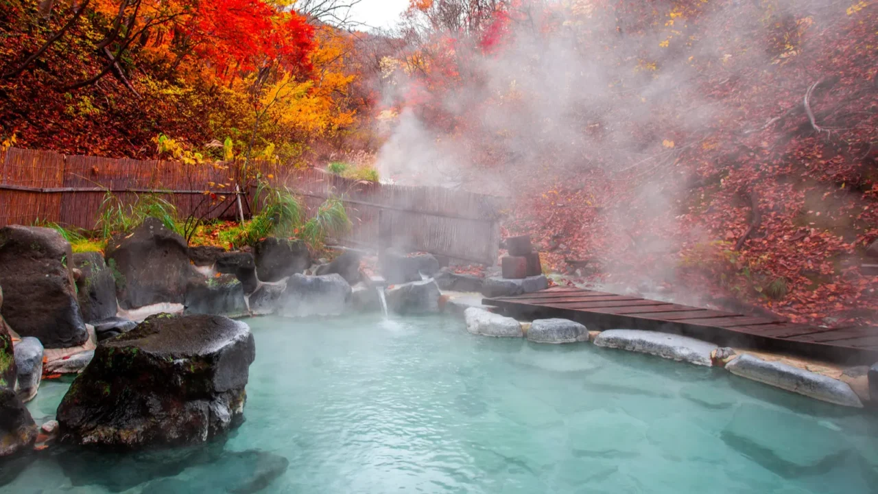 japanese hot springs onsen natural bath surrounded by redyellow leaves