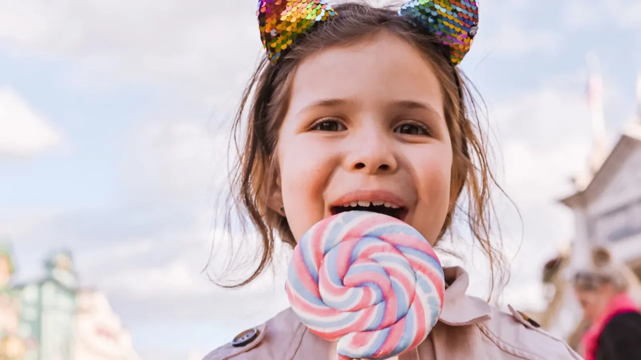 little girl with big lollipop is playing and having fun