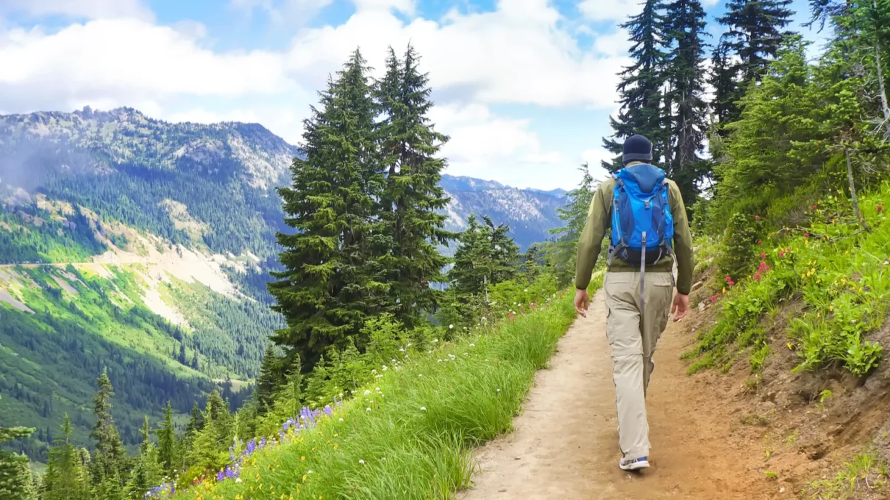 male hiker walking up the trail in the mountains near