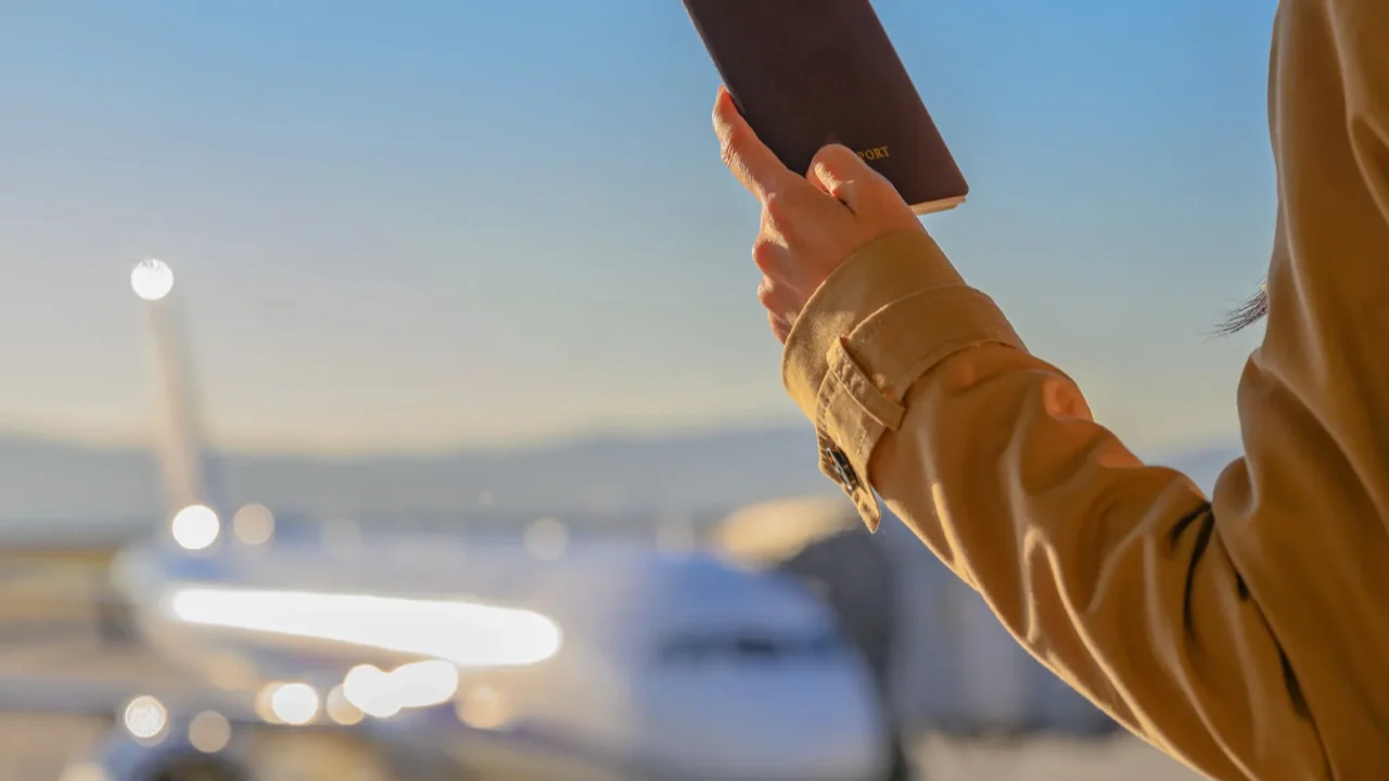 passport and boarding pass in hand of passenger woman stand