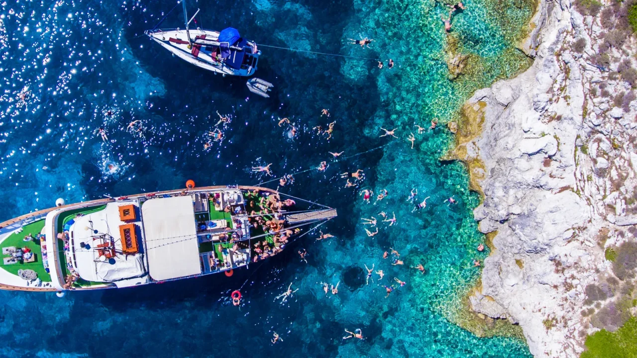 people swimming in the clear blue waters of antipaxos island