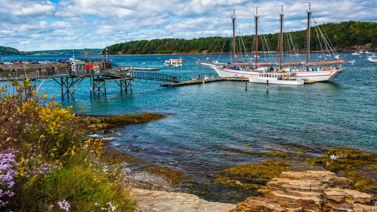 rocky coast and view of boats in the harbor at