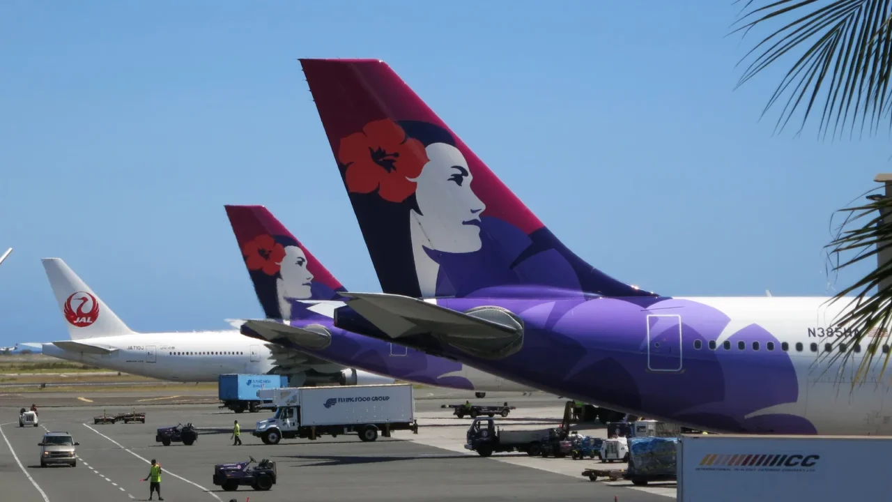 tails of hawaiian airlines and japan airlines airplanes as they