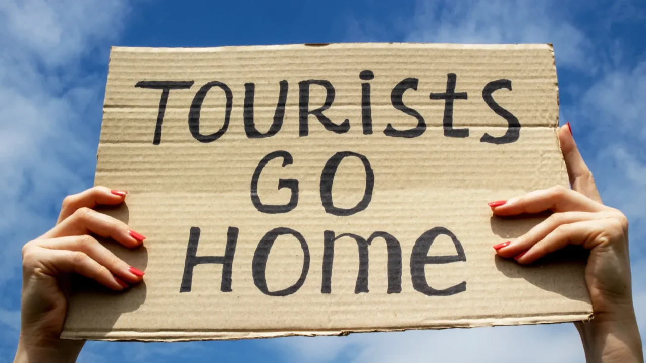text tourists go home on a cardboard plate in hands