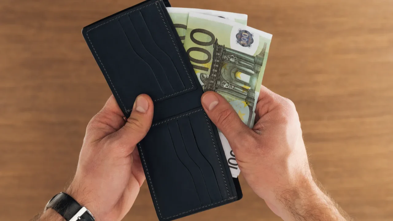 top view of man puting euros banknotes in wallet on