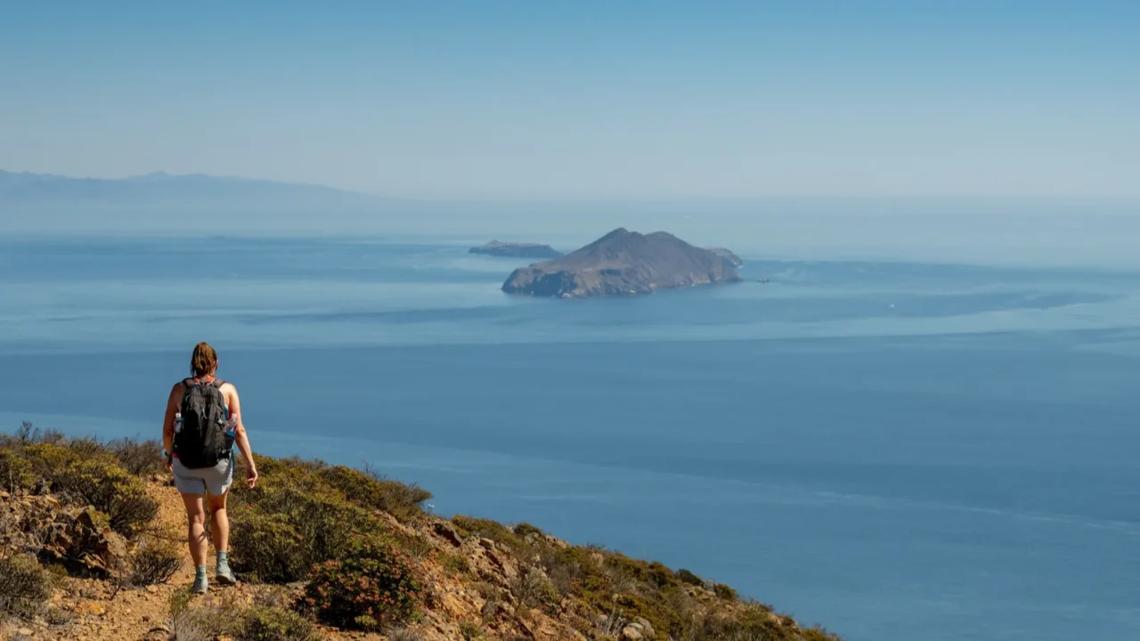 woman hikes on santa cruz island with anacapa in the