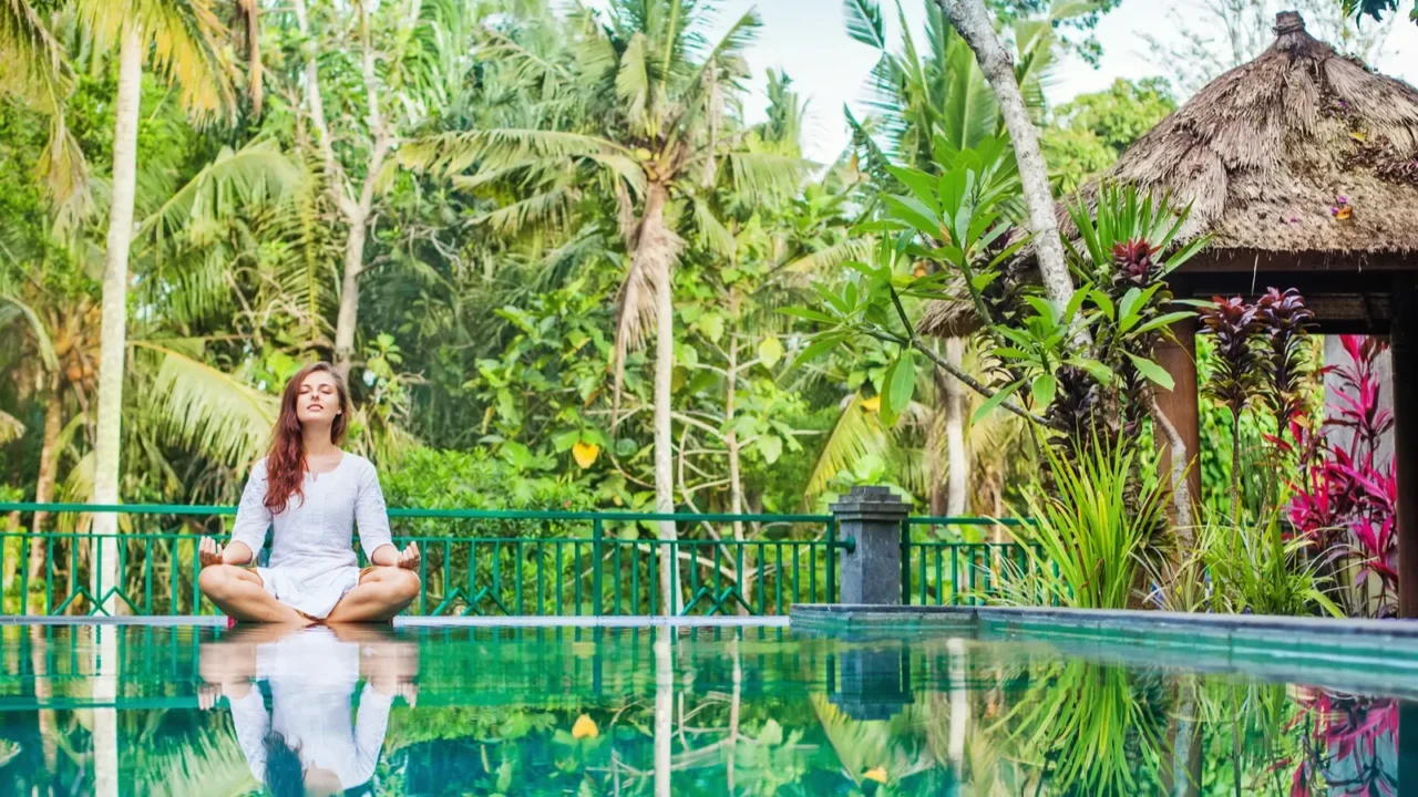 woman meditating at pool side