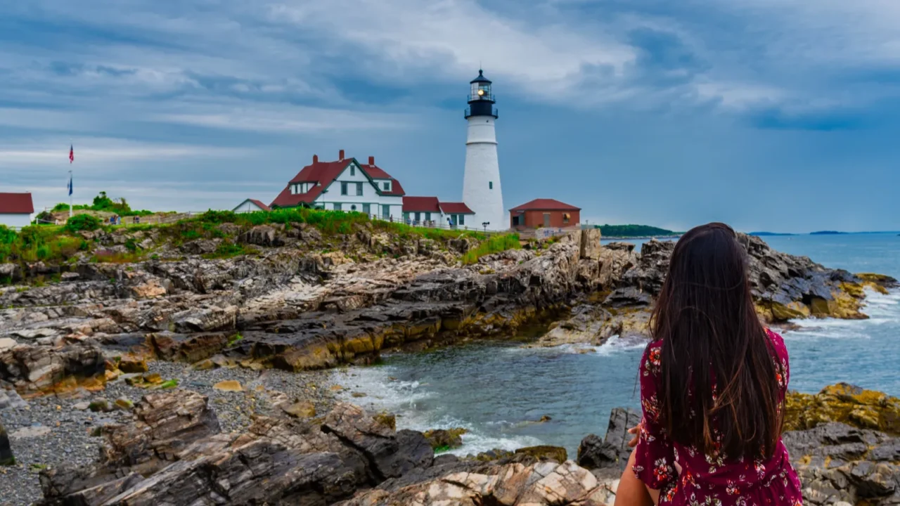 woman mesmerizing the view of portland head lighthouse in portland