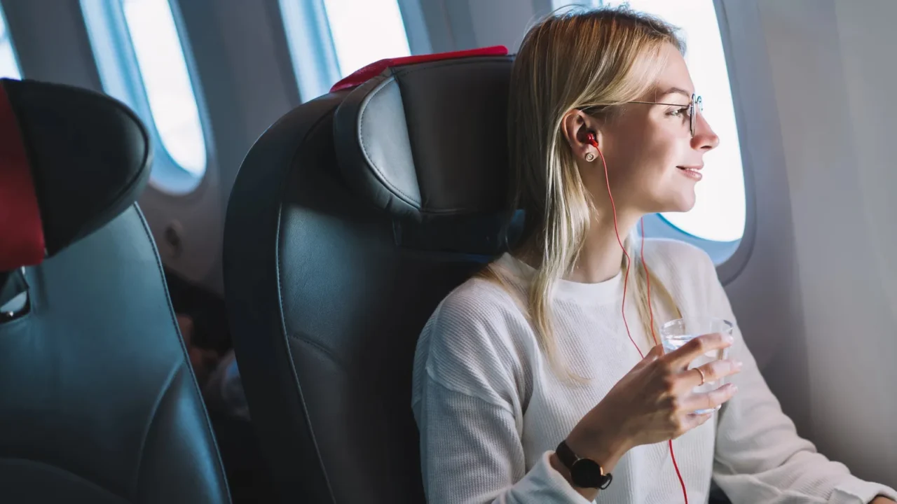 young caucasian smiling female enjoying her comfortable flight while sitting