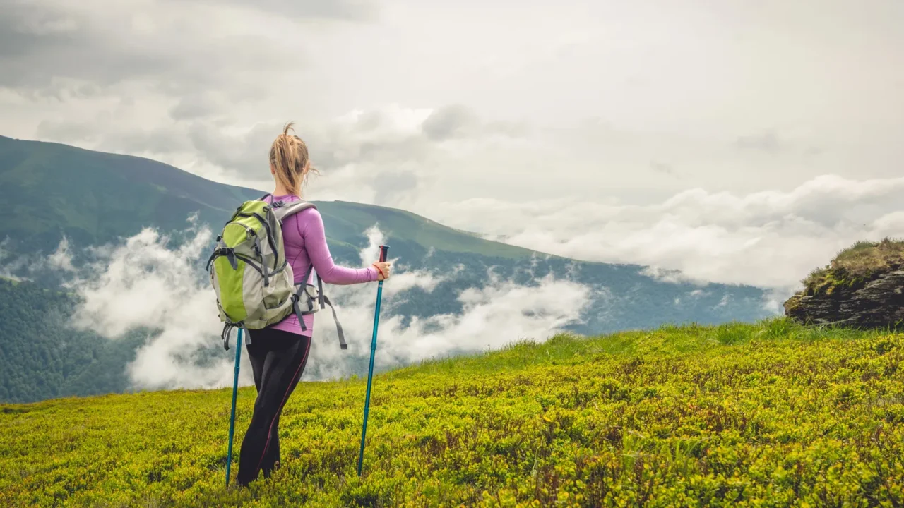 Young woman with backpack hiking in the mountains.
