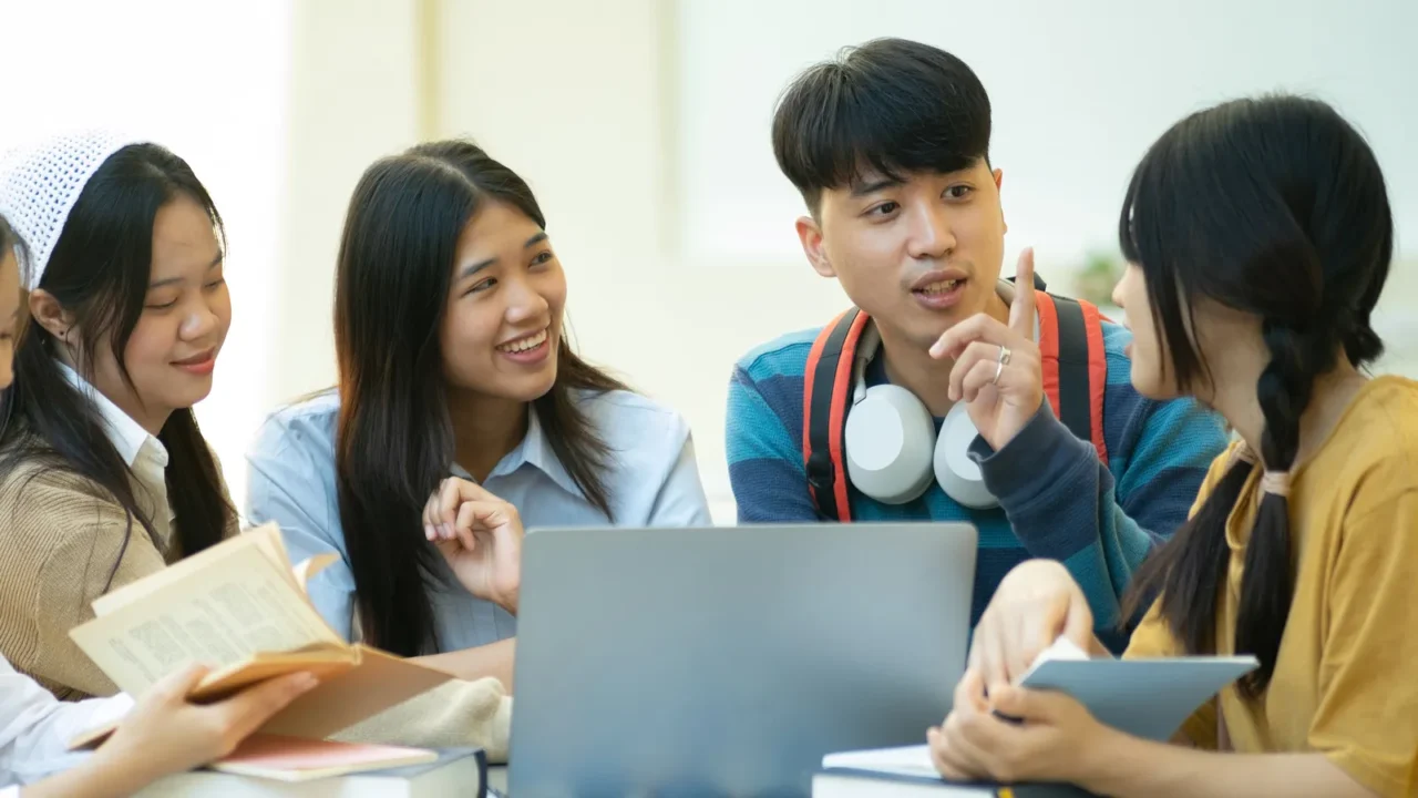 a group of college students studying together outdoors on campus