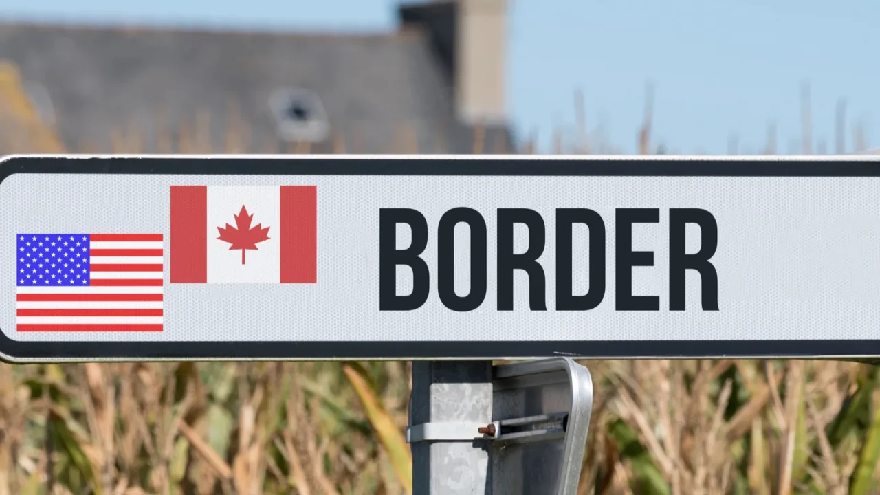 a sign indicates the border between usa and canada