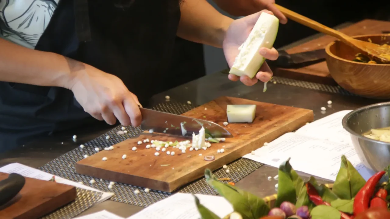 adult students learning recipe and preparing meal in cooking class