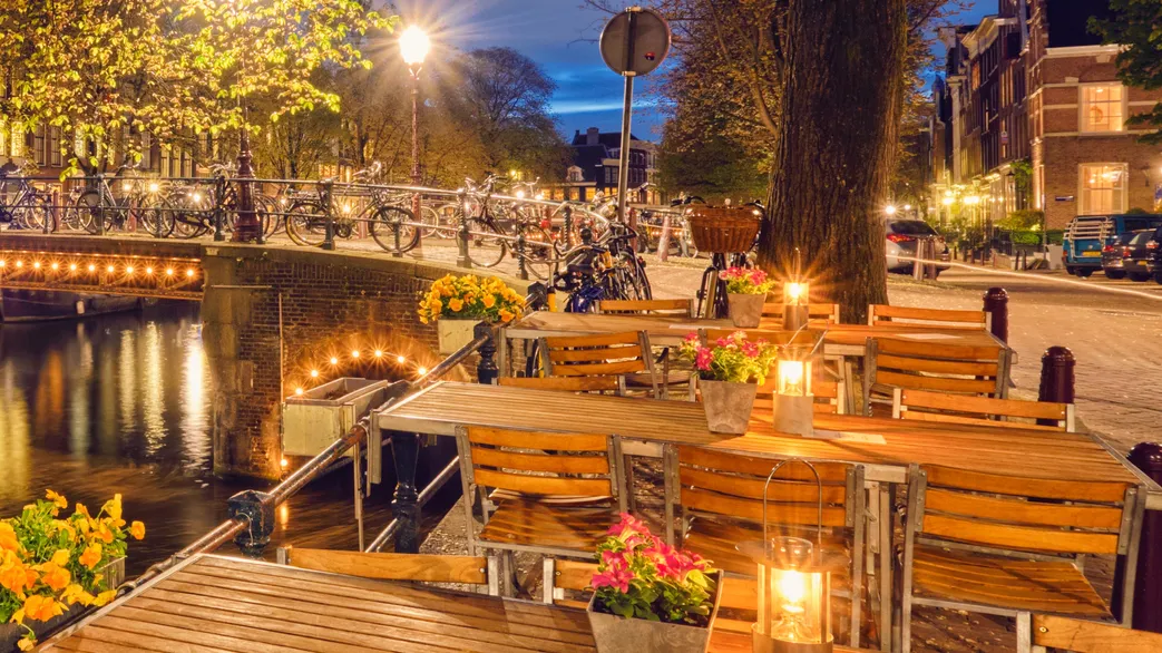 amterdam cafe tables canal bridge and medieval houses in the