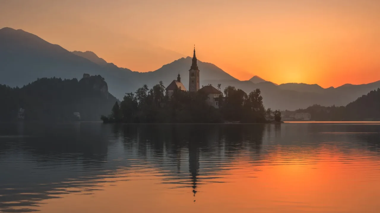 an island with church in bled lake slovenia at sunrise