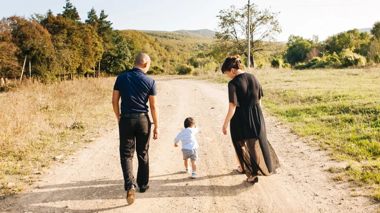 asian family walking by field with little son