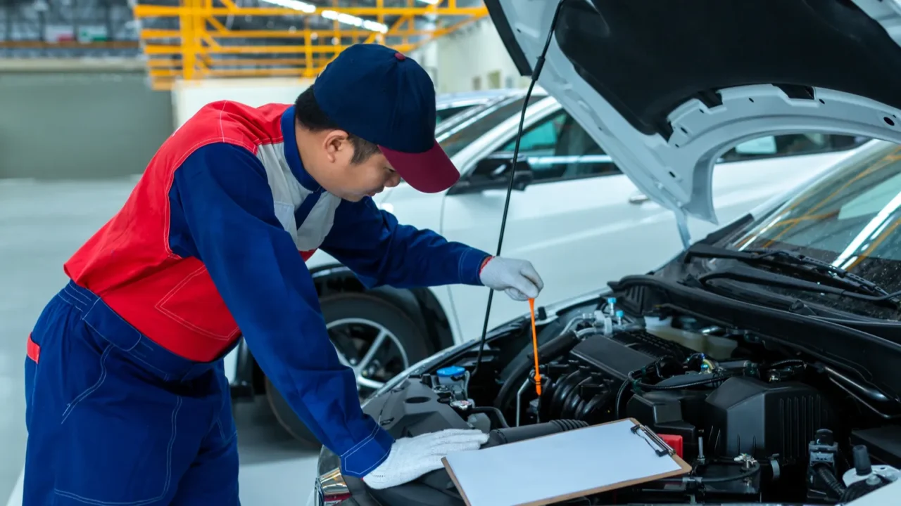 auto mechanic checking car engine oil in car auto repair