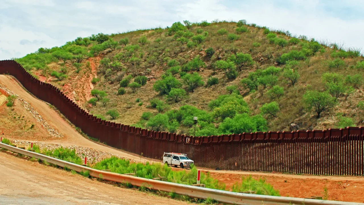 border fence beside a road near nogales arizona separating the