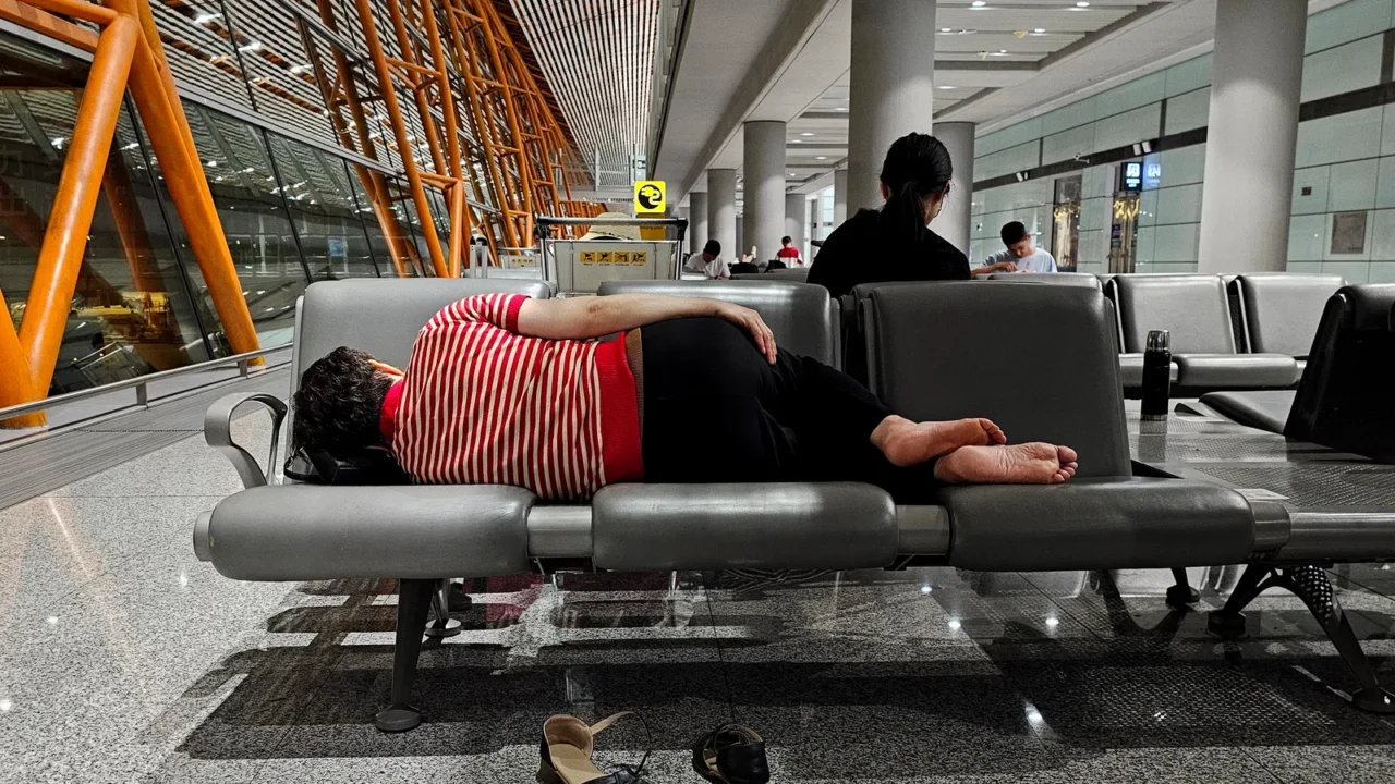 chinese woman sleeping on a bench at the airport terminal