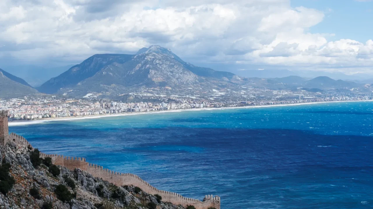 cityscape of alanya and ancient walls from hill and clouds