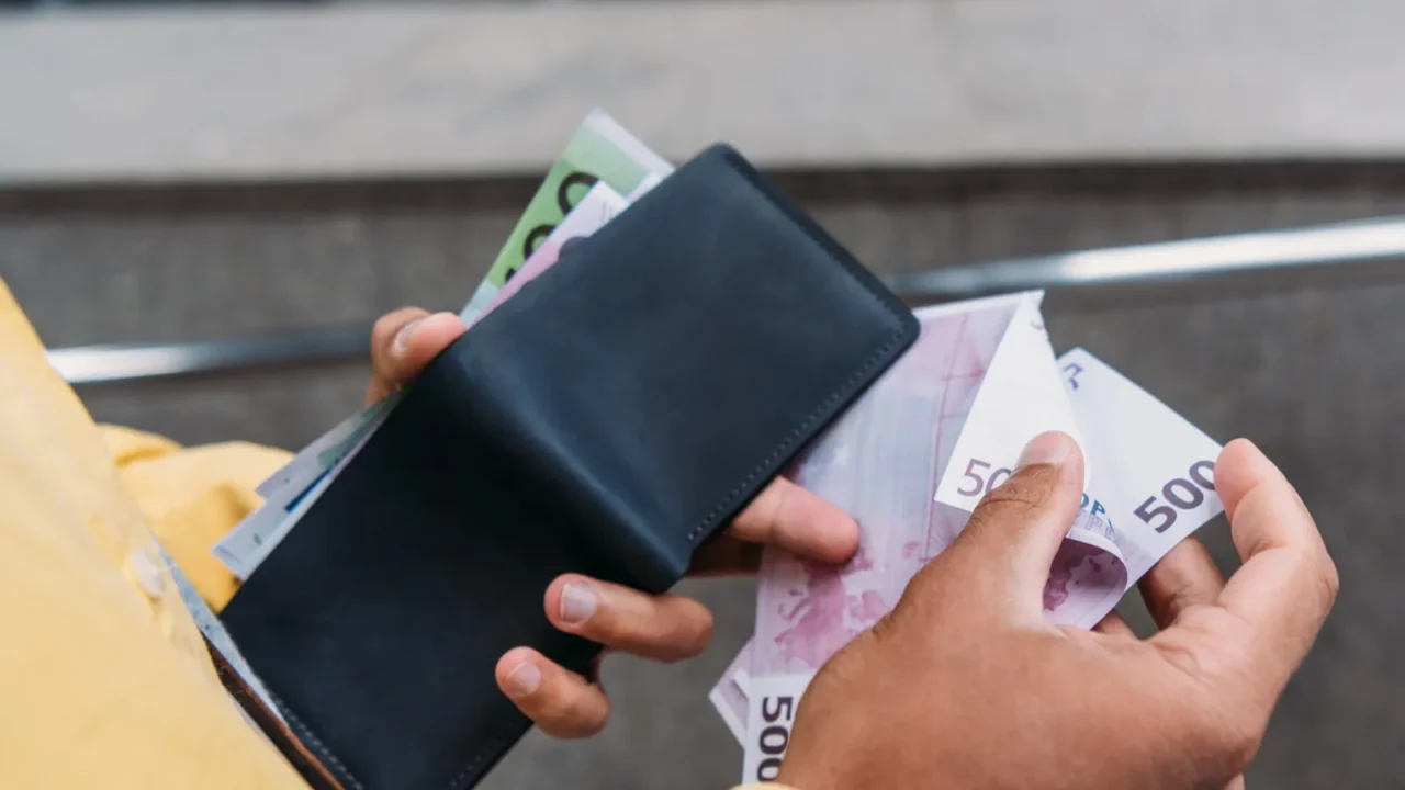 cropped view of mixed race man holding wallet and counting