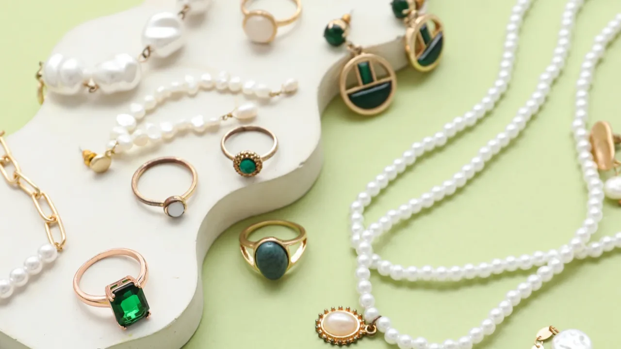 decorative podium with different jewelry on green background closeup