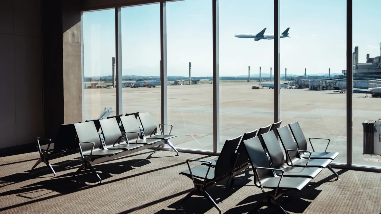 empty airport terminal seating area with a large window view