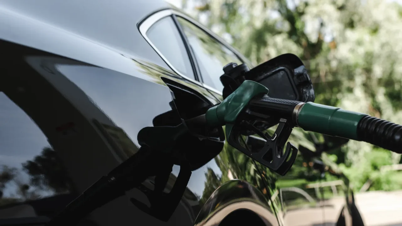 fueling nozzle in gas tank of car on gas station