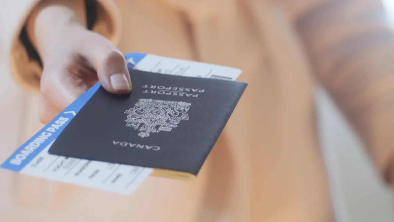 girl holds canadian passport and boarding passport