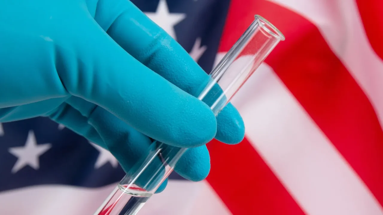 gloved hand holding a medical test tube against the background