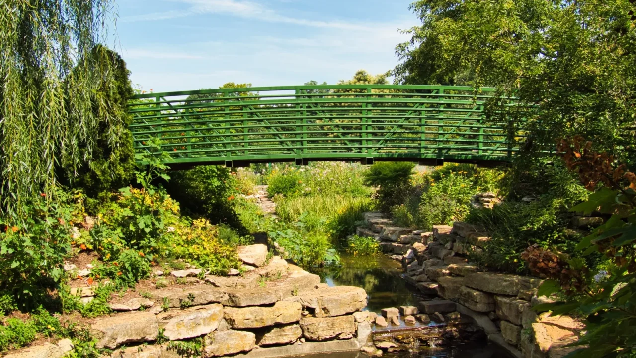 green bridge in the middle of a flower garden in