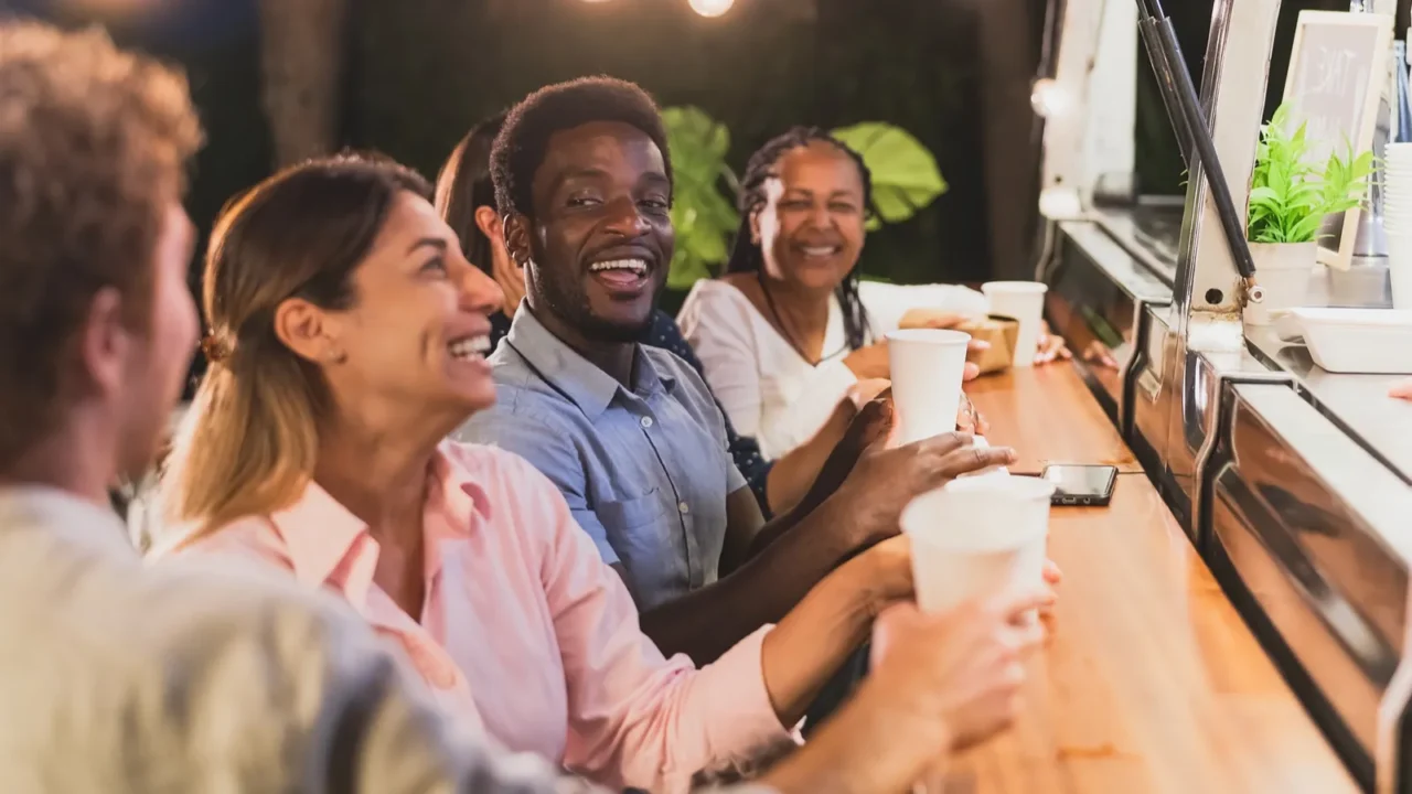 happy multiracial people buying meal from food truck kitchen
