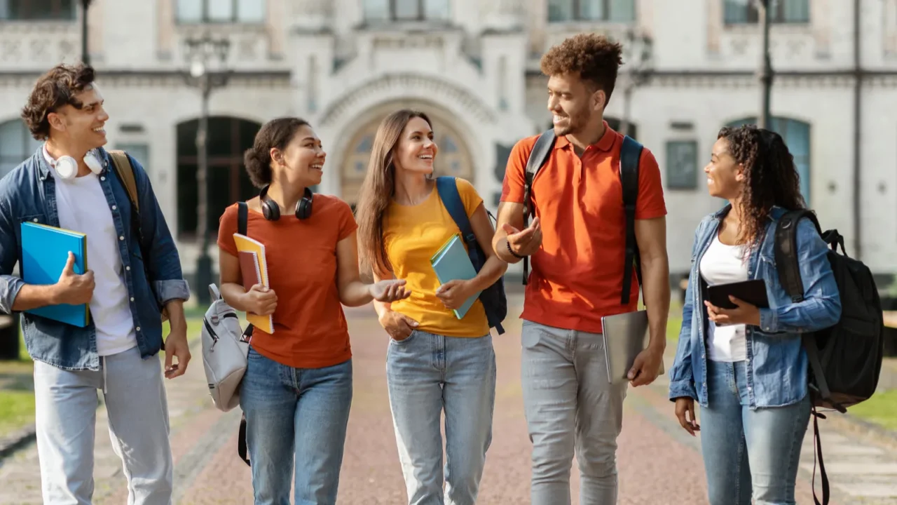 happy university students walking together on campus gropu of cheerful