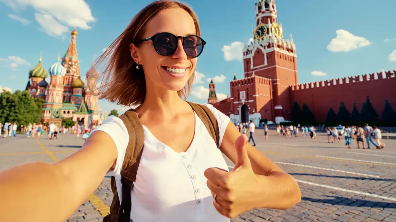 happy young woman taking selfie on red square in moscow