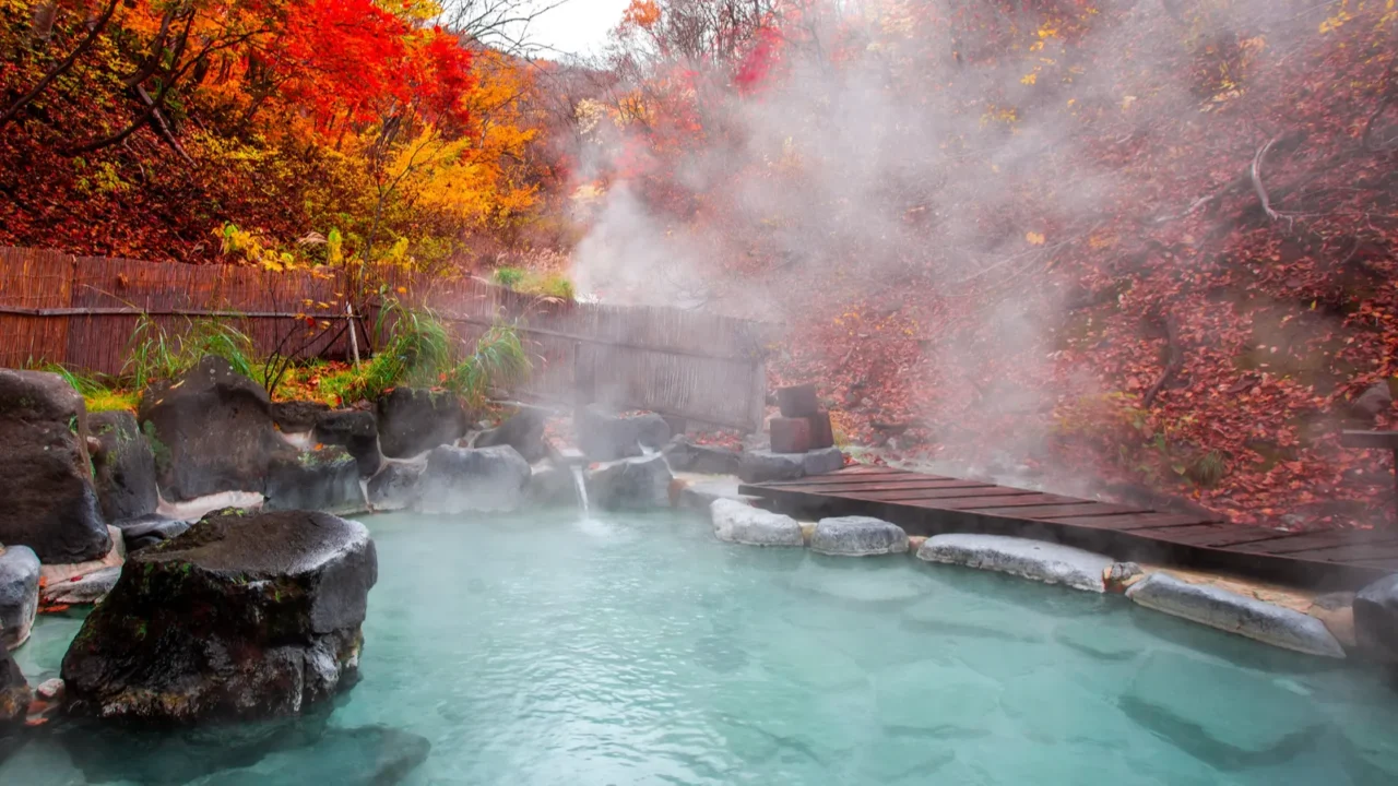 japanese hot springs onsen natural bath surrounded by redyellow leaves