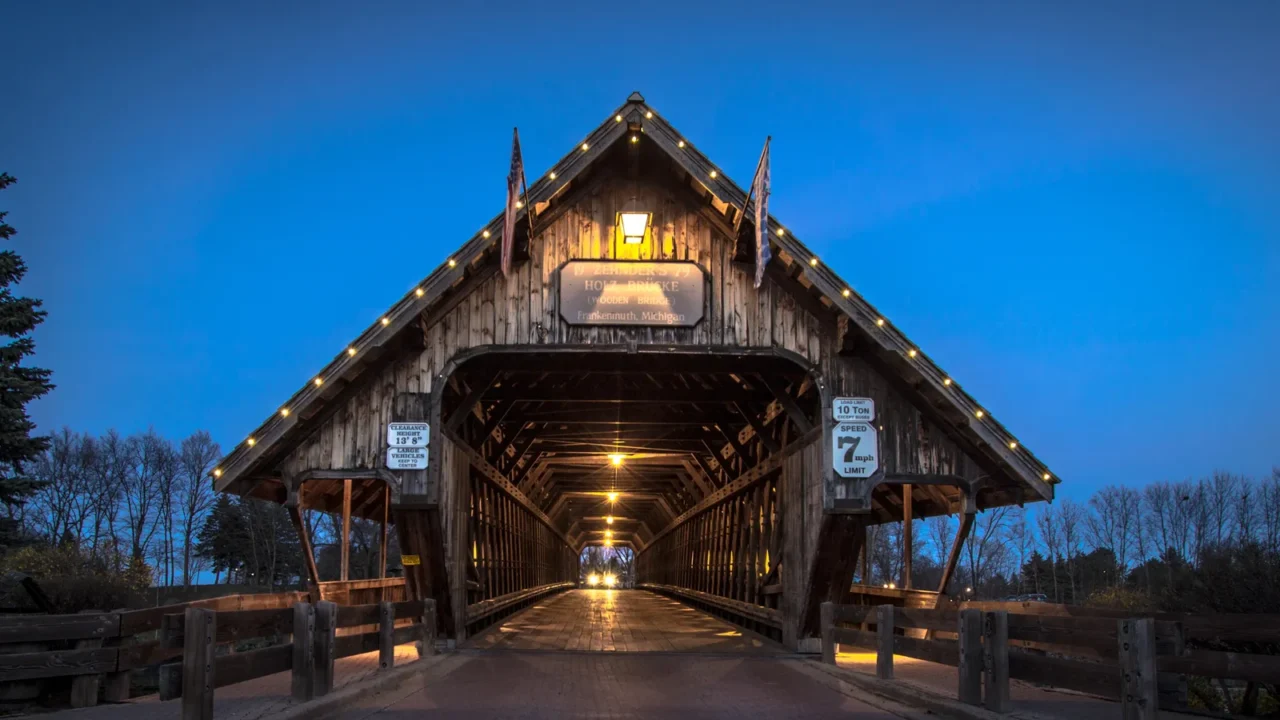 michigan covered bridge car entering historic covered bridge illuminated at