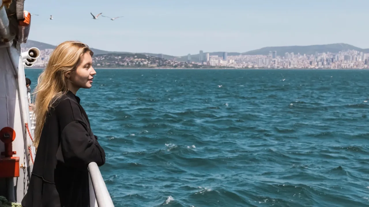 side view of happy woman in black sweater looking at