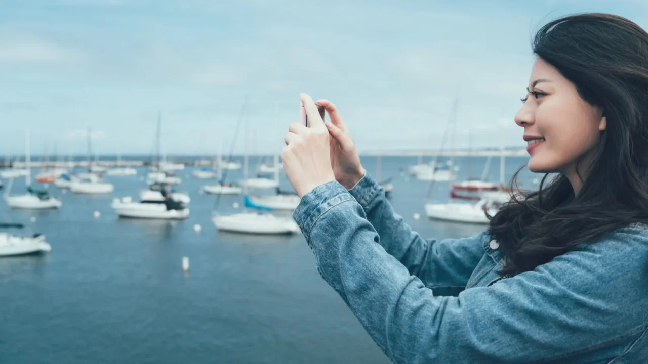 side view of young asian woman tourist taking photo of