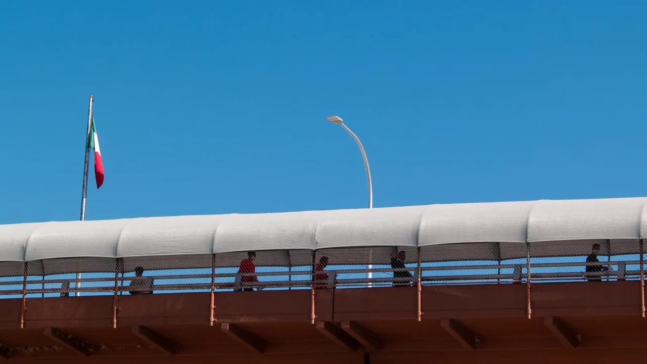 silhouettes of migrants crossing an international bridge into the usmexico
