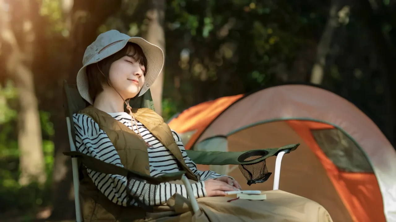 A young woman taking a nap in front of a tent