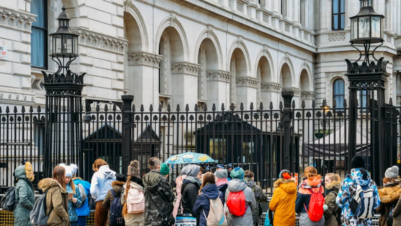 tourists in front of the gated entrance to 10 downing