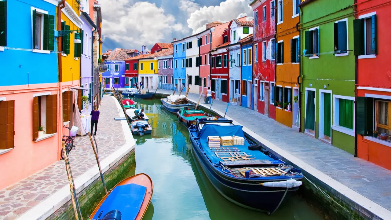 Venice, Burano island canal, small colored houses and the boats