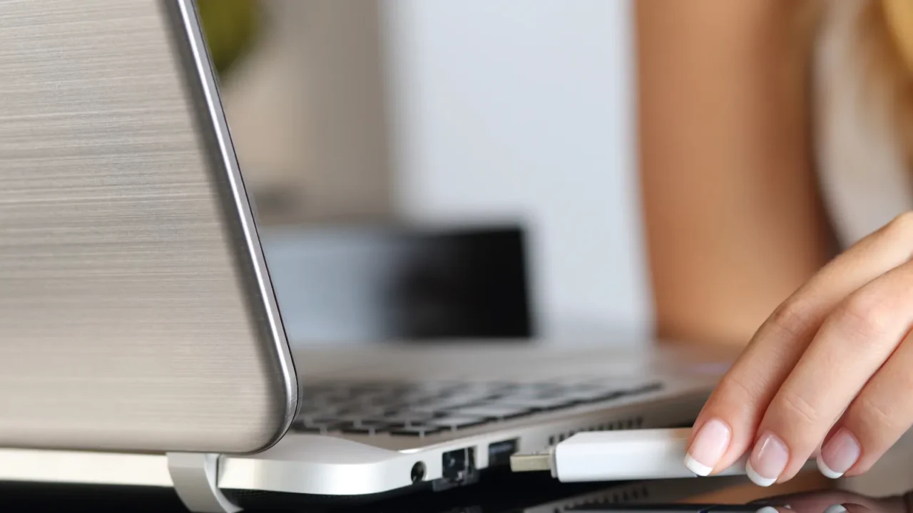 woman hand plugging an usb pendrive on a laptop