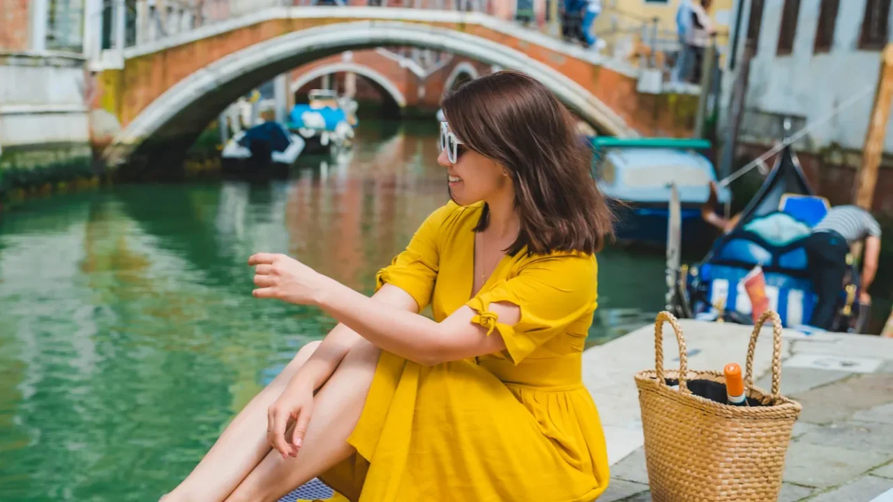 woman sitting on pond with view of venice canal eating