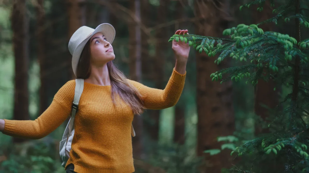Front view of young woman on a walk outdoors in forest in summer nature, walking.