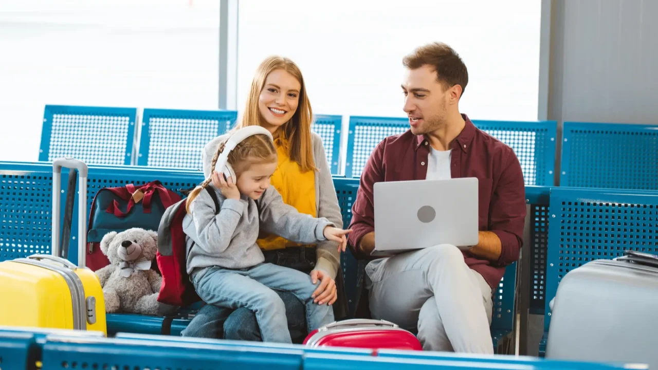 adorable daughter pointing with finger at laptop while sitting near